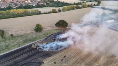 clouds of smoke after farm field fire essex uk fire engine attending drone,aerial