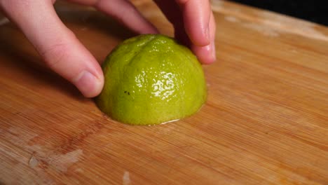 las manos del chef cortando medio limón en cuartos y moviéndolo en su mano