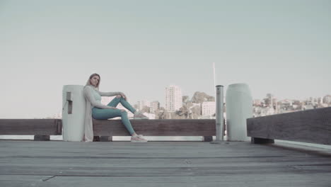 Woman-sitting-and-relaxing-on-the-wharf-on-the-morning