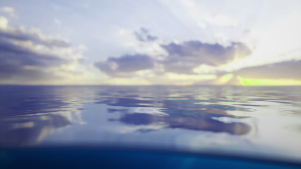 Calm ocean water reflects clouds and sunset colors in serene beauty