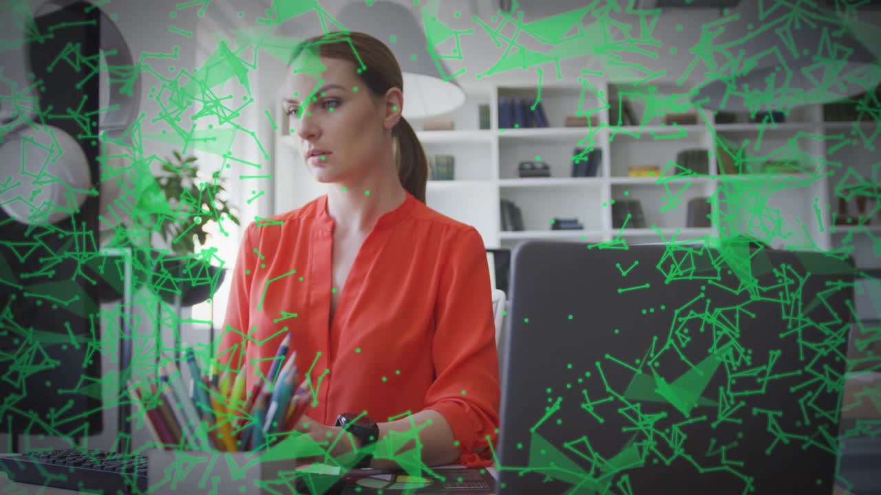 Donna che digita alla scrivania dell'ufficio domestico, attivando una sovrapposizione poligonale verde che visualizza il flusso di dati tecnologici.