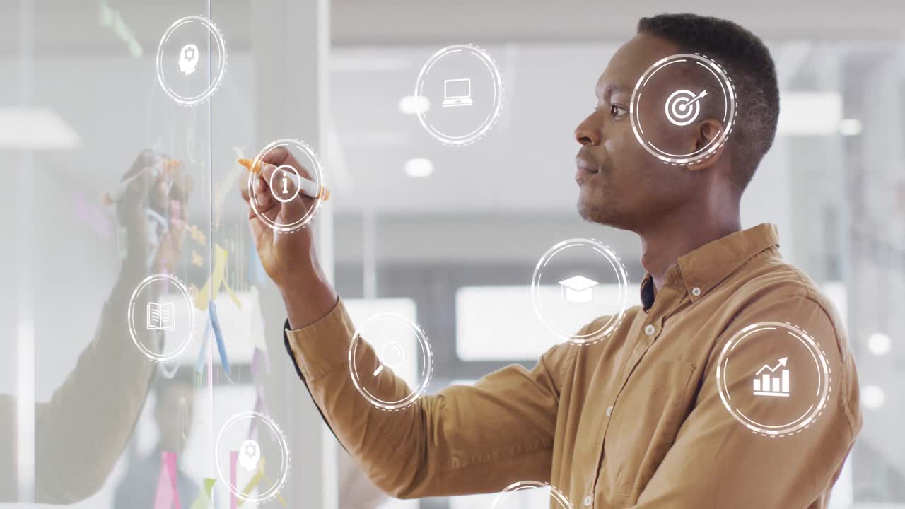 Animation of financial data with icons over african american businessman writing on whiteboard
