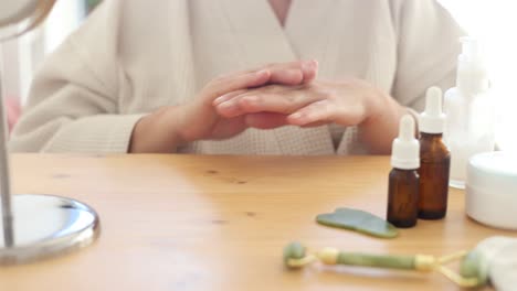 mujer goteando producto cosmético en las manos