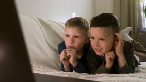 excited kids enjoying film on the sofa