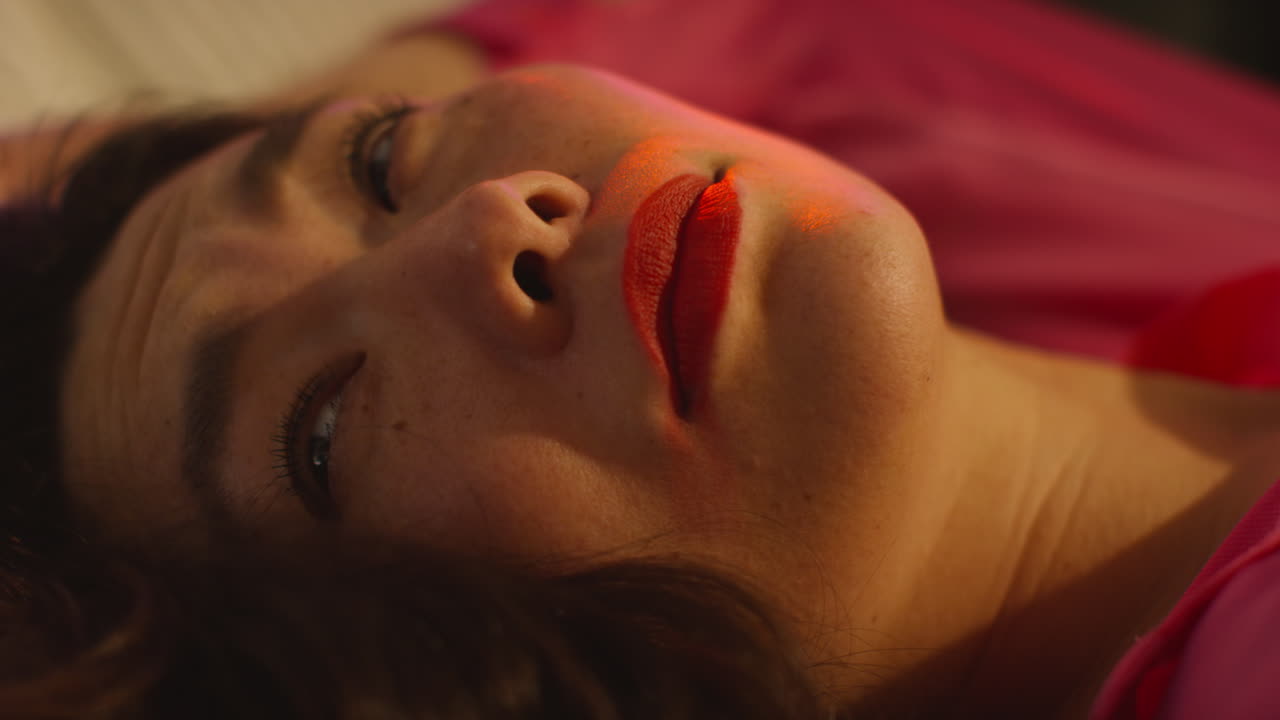 un primer plano de una mujer que se despierta en el sofá después de beber alcohol en una fiesta de casa sufriendo de resaca.