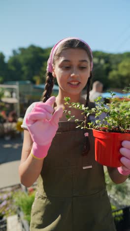 young woman inspecting a plant at a garden center