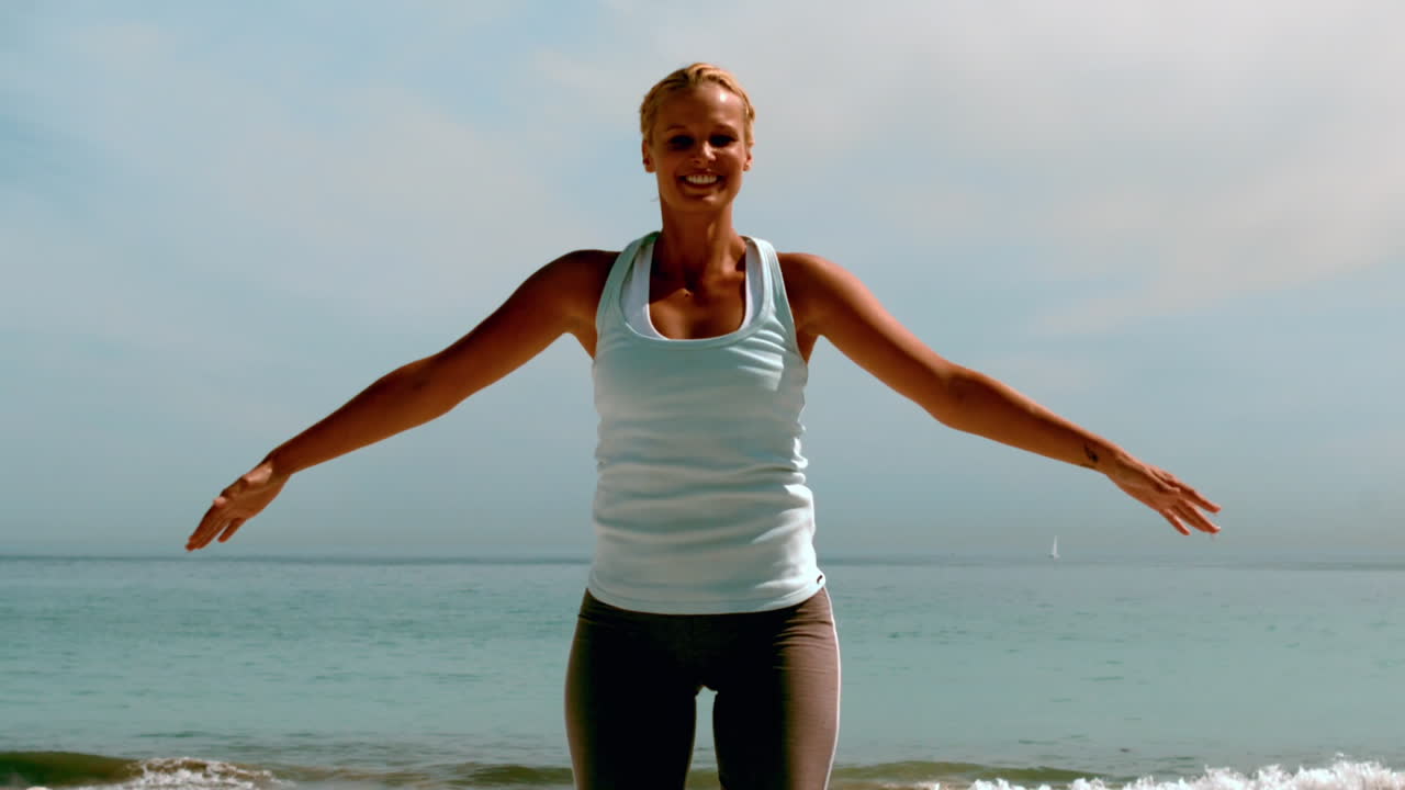 해변 에서 점프 잭 을 하는 운동선수