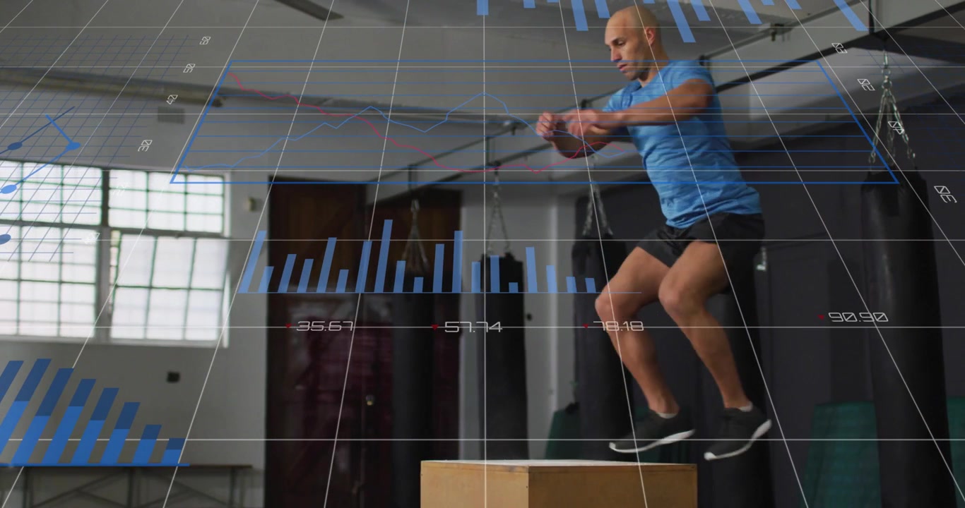 Crouching, mid-adult man in blue shirt launching plyo box jumps for training, gym HUD, copy space