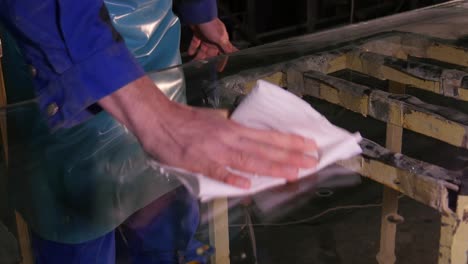 worker cleaning glass at factory