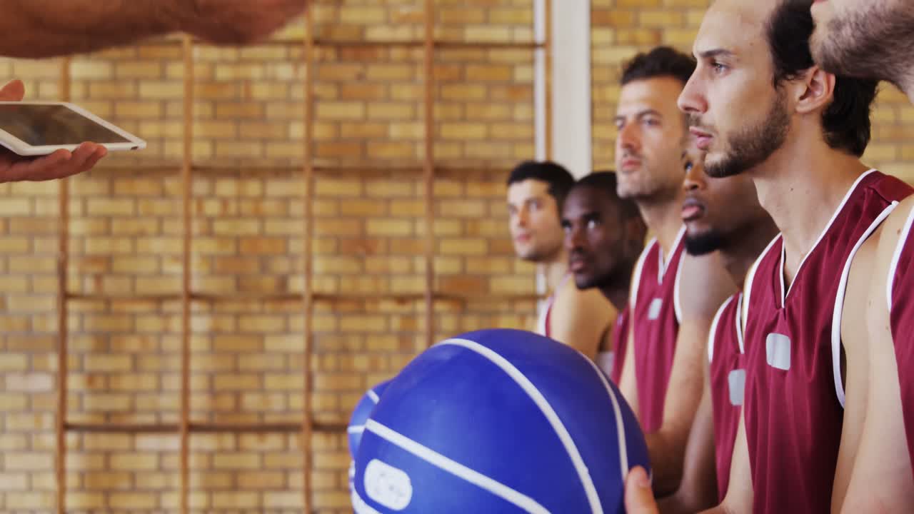 entrenador de baloncesto ayudando a los jugadores en una tableta digital