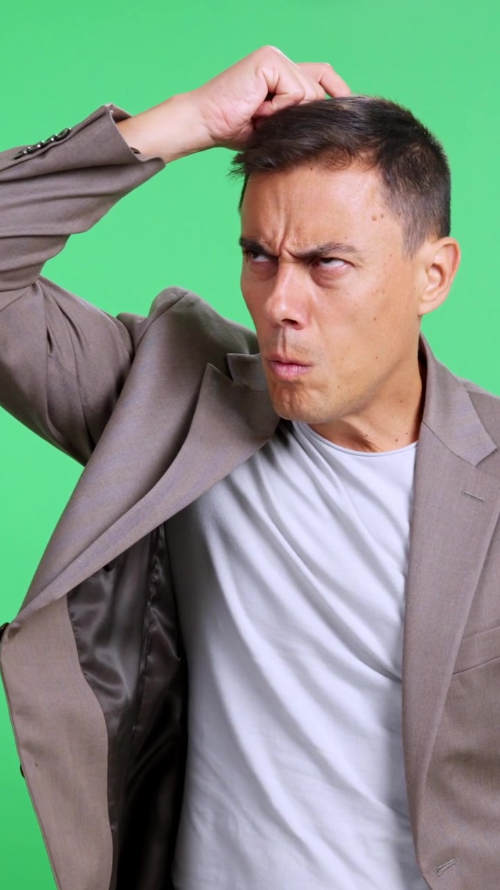 Confused and puzzled businessman thinking on green screen
