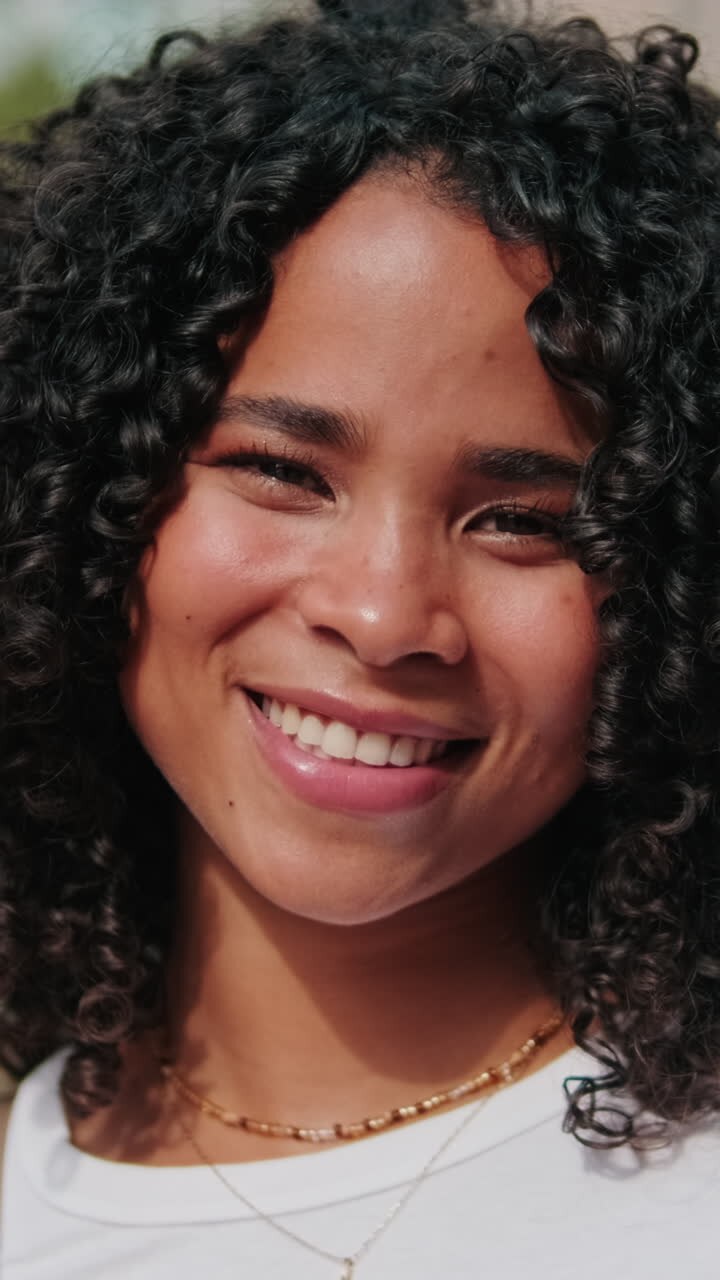Portrait of young curly African-American girl, female student sincerely smiling