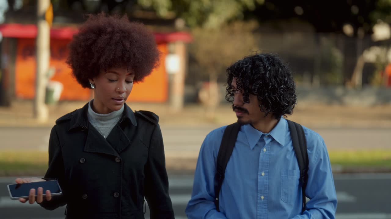 Young man and woman walking and interacting on a city street