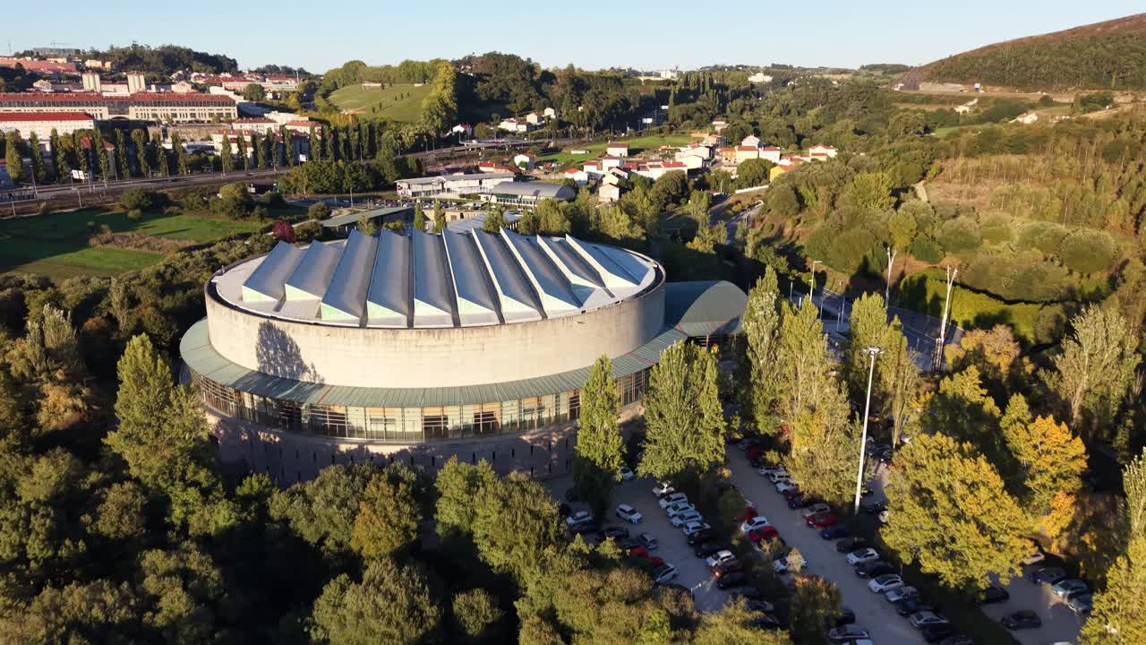 4K drone video of the Multiusos Fontes do Sar in Santiago de Compostela. The sunset recording shows the building's modern architecture and the golden light reflected on it. Spain. Galicia