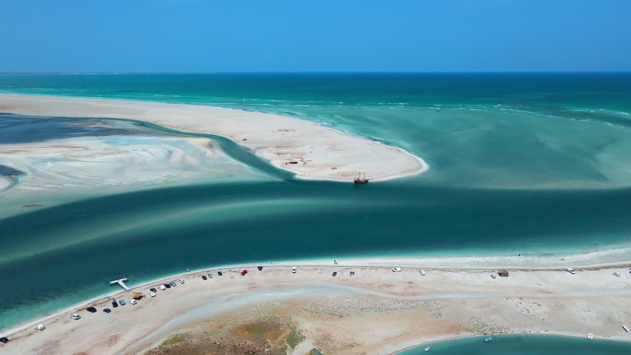 Et luftfoto af strandscenen ved Hassi El Jerbi med mennesker og både i vandet ved Zarzis, Tunesien.
