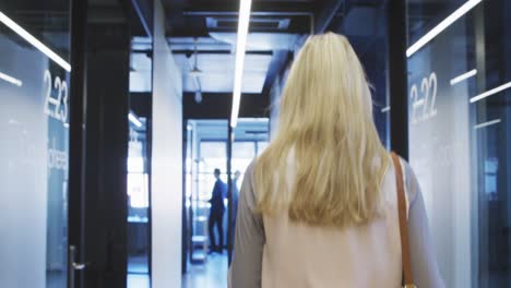 Businesswoman-working-while-walking-in-modern-office