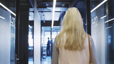 mujer de negocios trabajando mientras camina en una oficina moderna