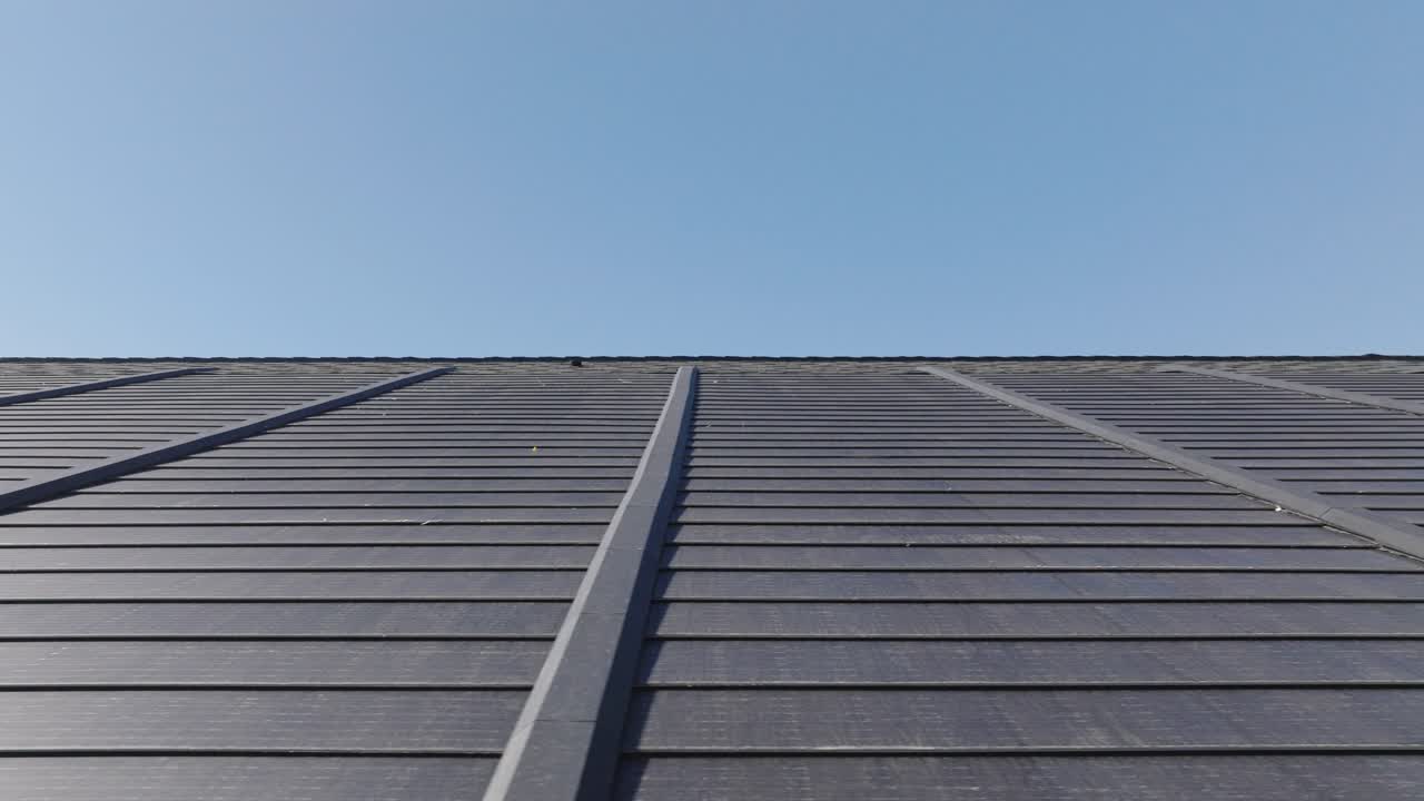 은 파란 하늘 아래 상업용 건물 지붕에 설치된 태양 전지.