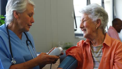 female doctor checking blood pressure of senior woman 4k