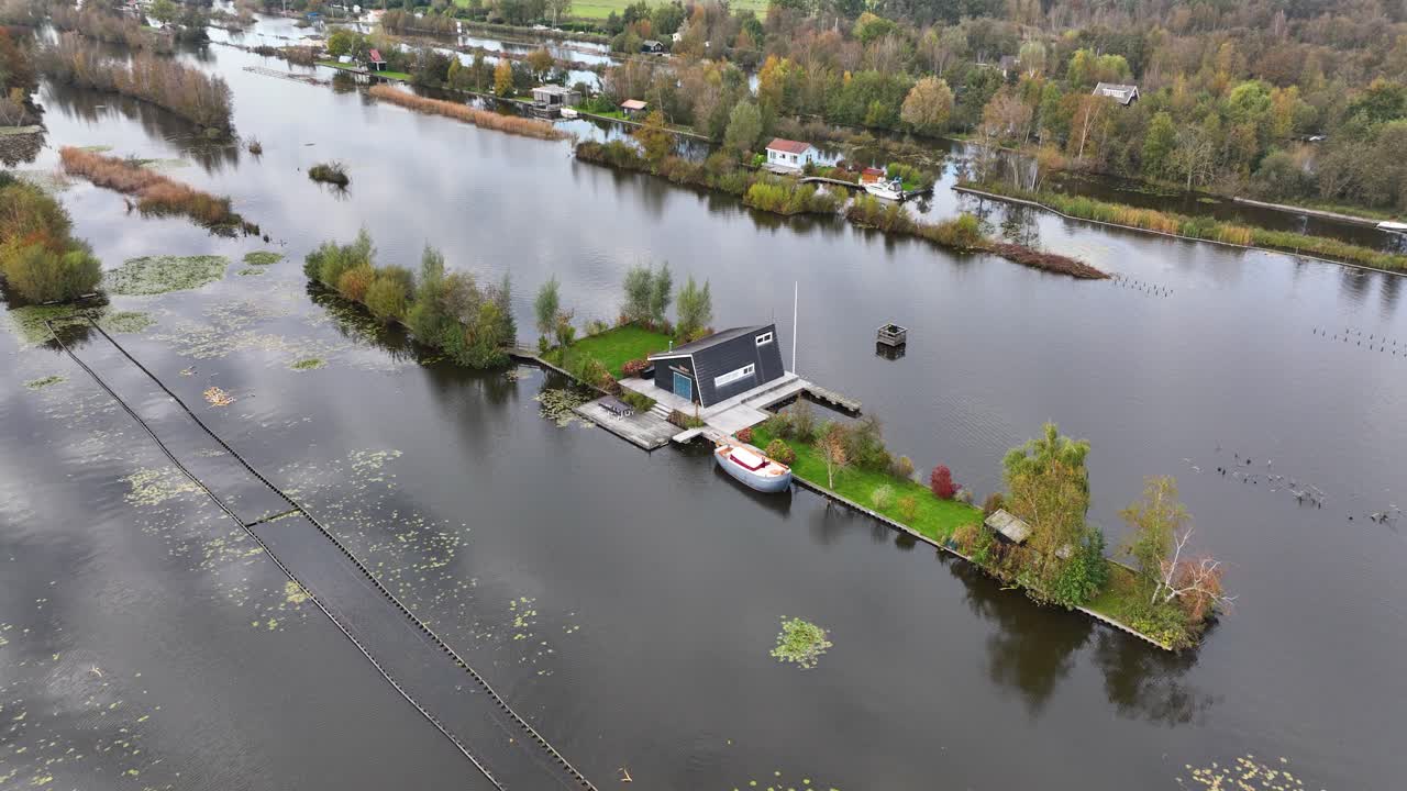 Small leisure house at miniature islands, Loosdrecht, large water sports and nature reserve. Aerial drone video.