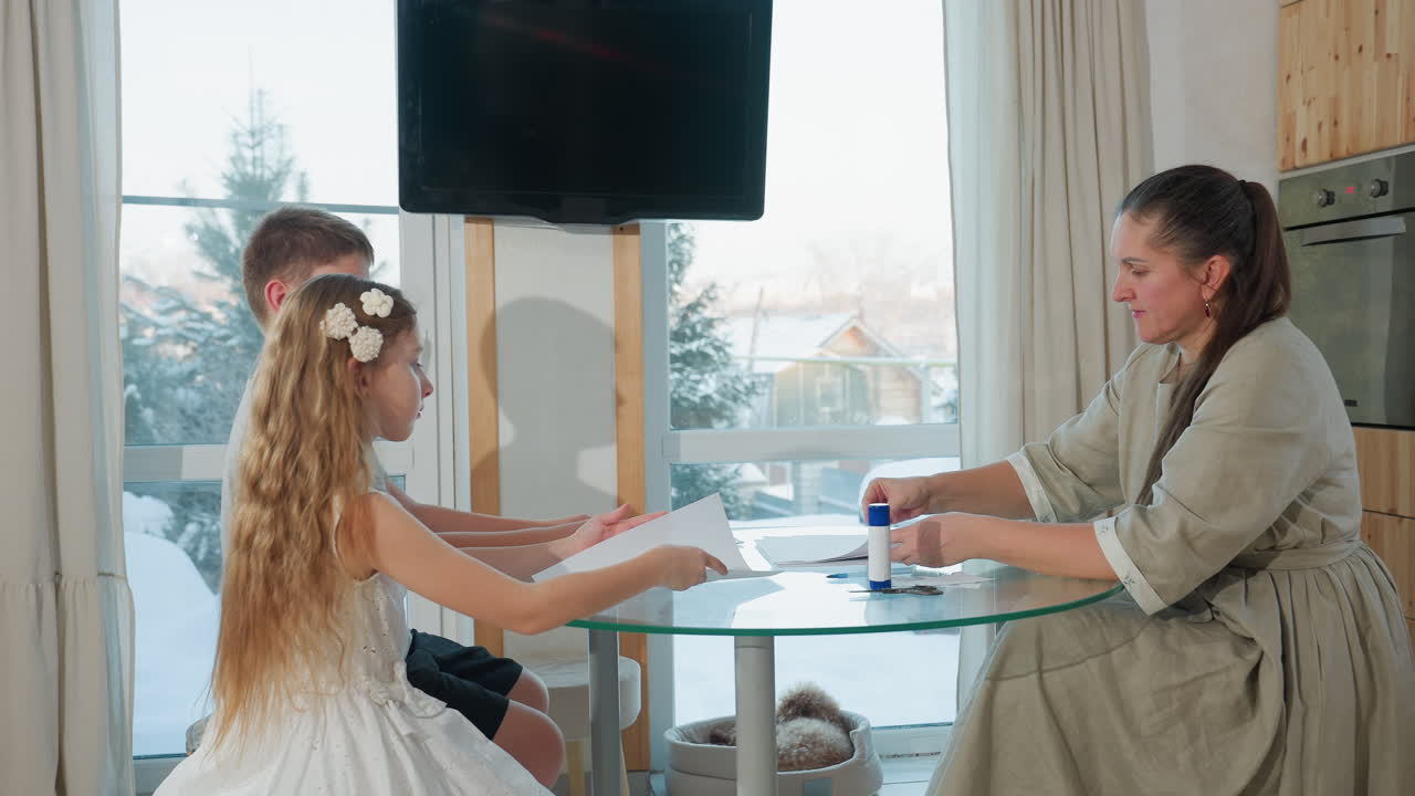 mom and kids sitting together, having fun moment, mom gives kids white paper sheet to fold, all dressed in casual wear, family bonding time, indoor creative activity at home