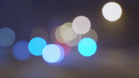 Blurred-bokeh-of-cars-and-traffic-lights-on-the-road-at-night,-abstract-colorful