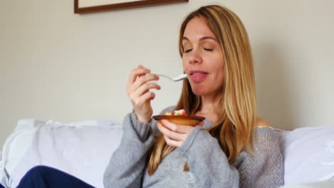 mujer desayunando en el dormitorio 4k