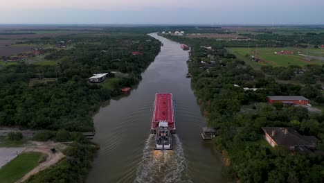 aerial video of a tankship navigating through a river in deep south texas