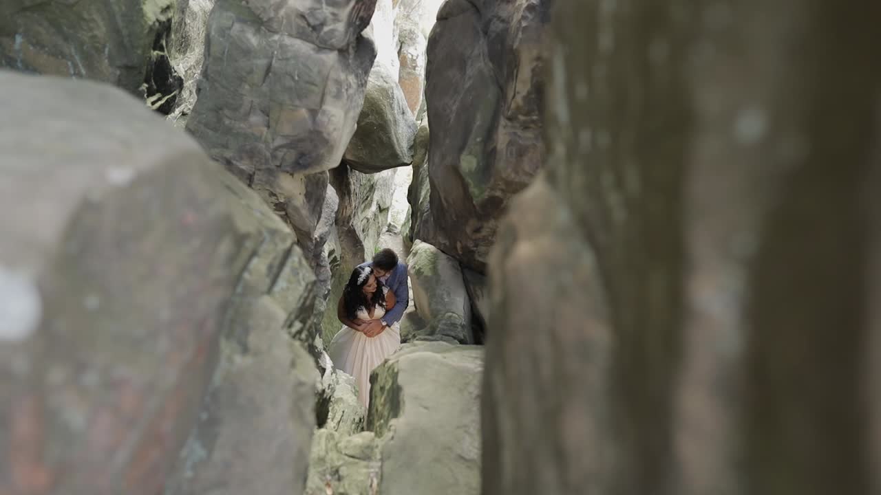 el novio con la novia de pie en la cueva de las colinas de la montaña.