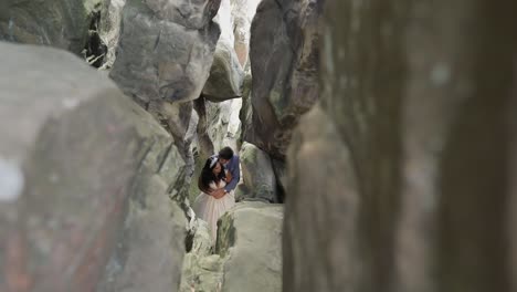 groom with bride standing in cave of mountain hills. wedding couple in love