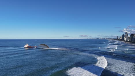 aerial view of a dredger pumping sand in the pacific ocean near gold coast, australia, under clear blue skies