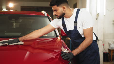 man detailing a red suv in a garage