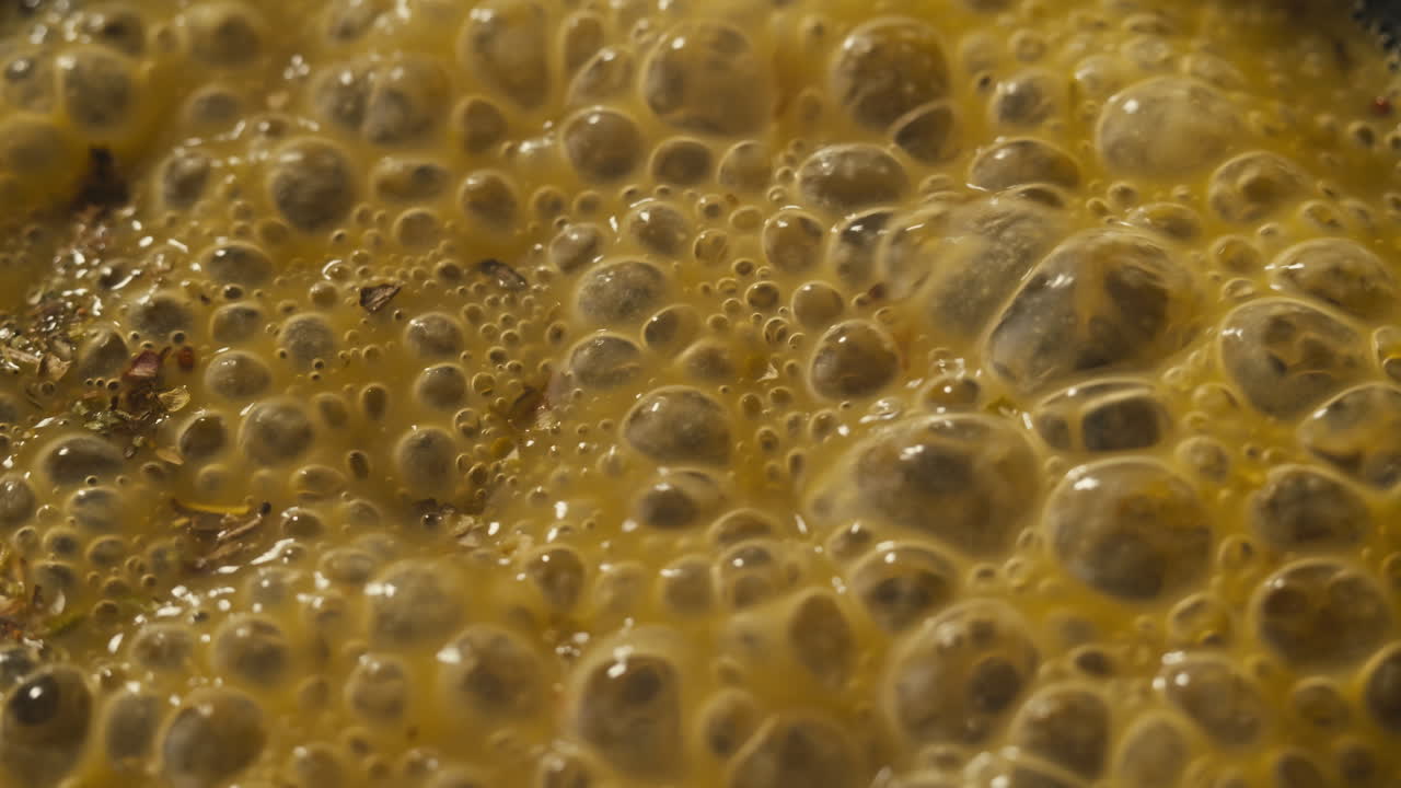 Green boiling sauce texture close-up macro. Cooking green curry with wooden spoon at home.
