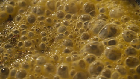 green boiling sauce texture close-up macro. cooking green curry with wooden spoon at home.