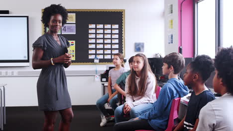 Línea-De-Alumnos-De-Secundaria-Siendo-Enseñados-Por-Una-Profesora-En-Clase-De-TIC