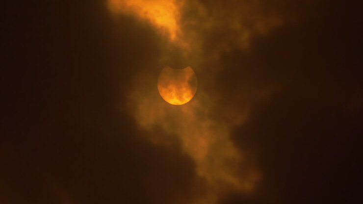 Beginning penumbra of an annular solar eclipse behind clouds, October 14th, 2023