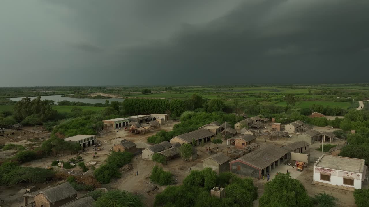 파키스탄 신드 주 미르푸르카스 (mirpurkhas, sindh) 의 초록색 농경지와 함께 시골 마을의 집 위에서 촬영된 공중 드론 트 다운.