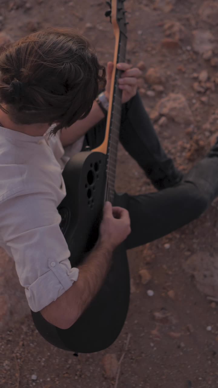 Man playing an acoustic guitar outdoors