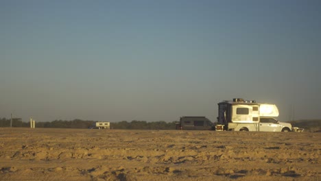 campistas de playa, furgonetas y camiones al atardecer en el parque nacional de la isla de assateague