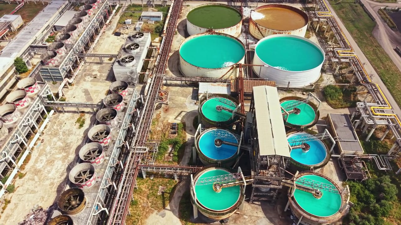 Industrial site with large tanks and machinery during daytime in a manufacturing location near a city
