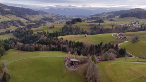 Vuelo-De-Drones-Sobre-Un-Paisaje-Montañoso-En-Un-Clima-Nublado-Con-Montañas-Al-Fondo