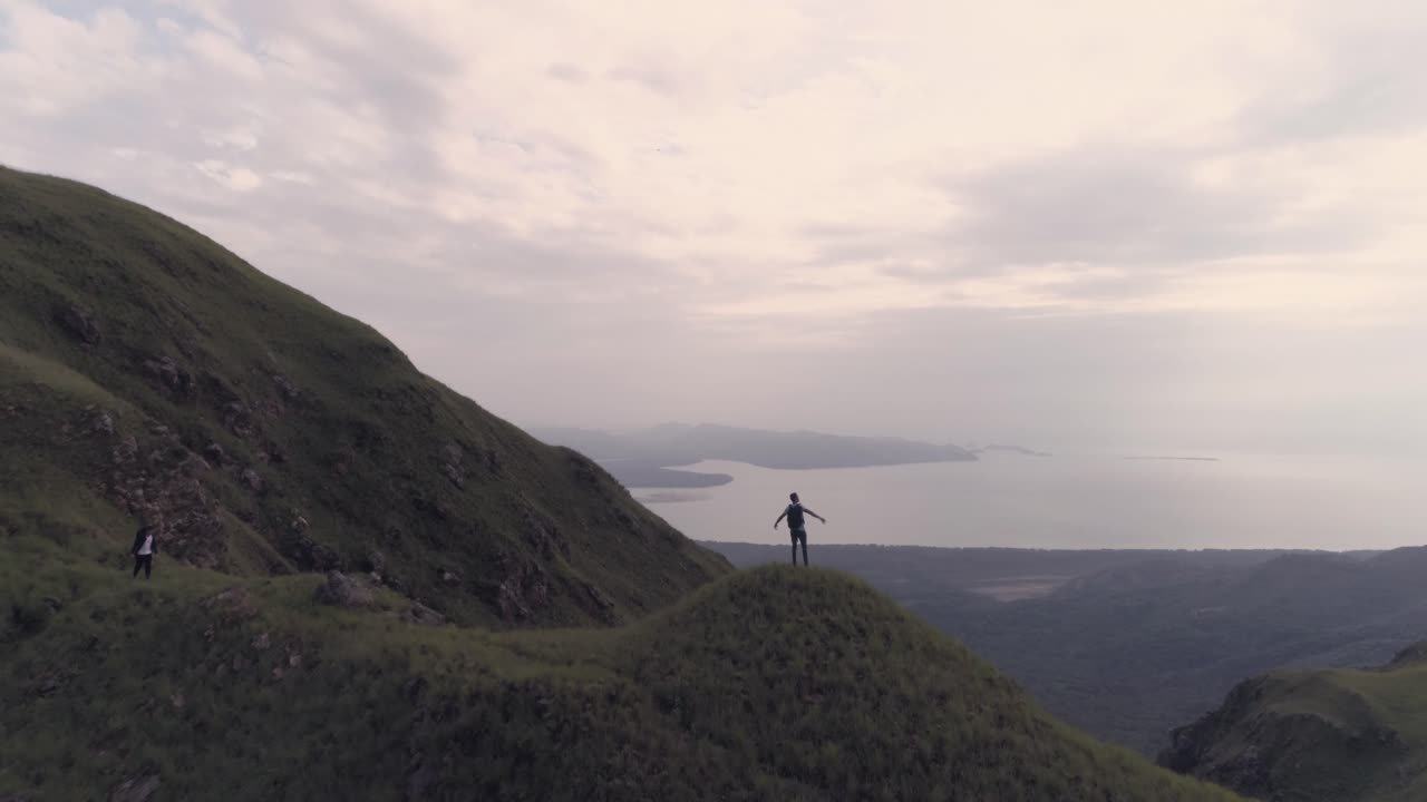 foto de drones de un hombre que levanta las manos después de llegar a la cima de la montaña cerro chame, distrito de chame, república de panamá
