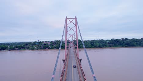 Adventure-between-Puerto-Maldonado's-bridge-pillars:-revealing-twist-among-cables,-towers,-and-city