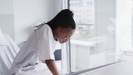 african american female patient in bed in hospital room, slow motion