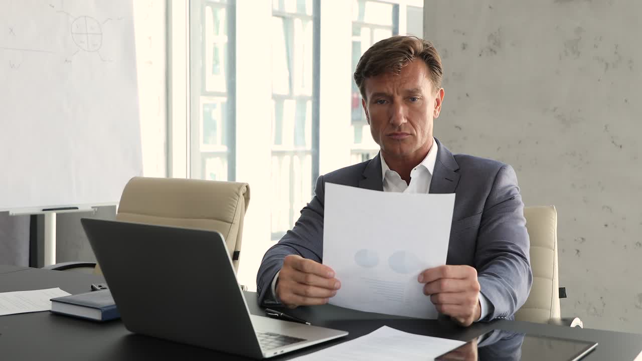 un hombre de negocios serio de mediana edad trabaja con estadísticas de ventas, analiza las ganancias del proyecto