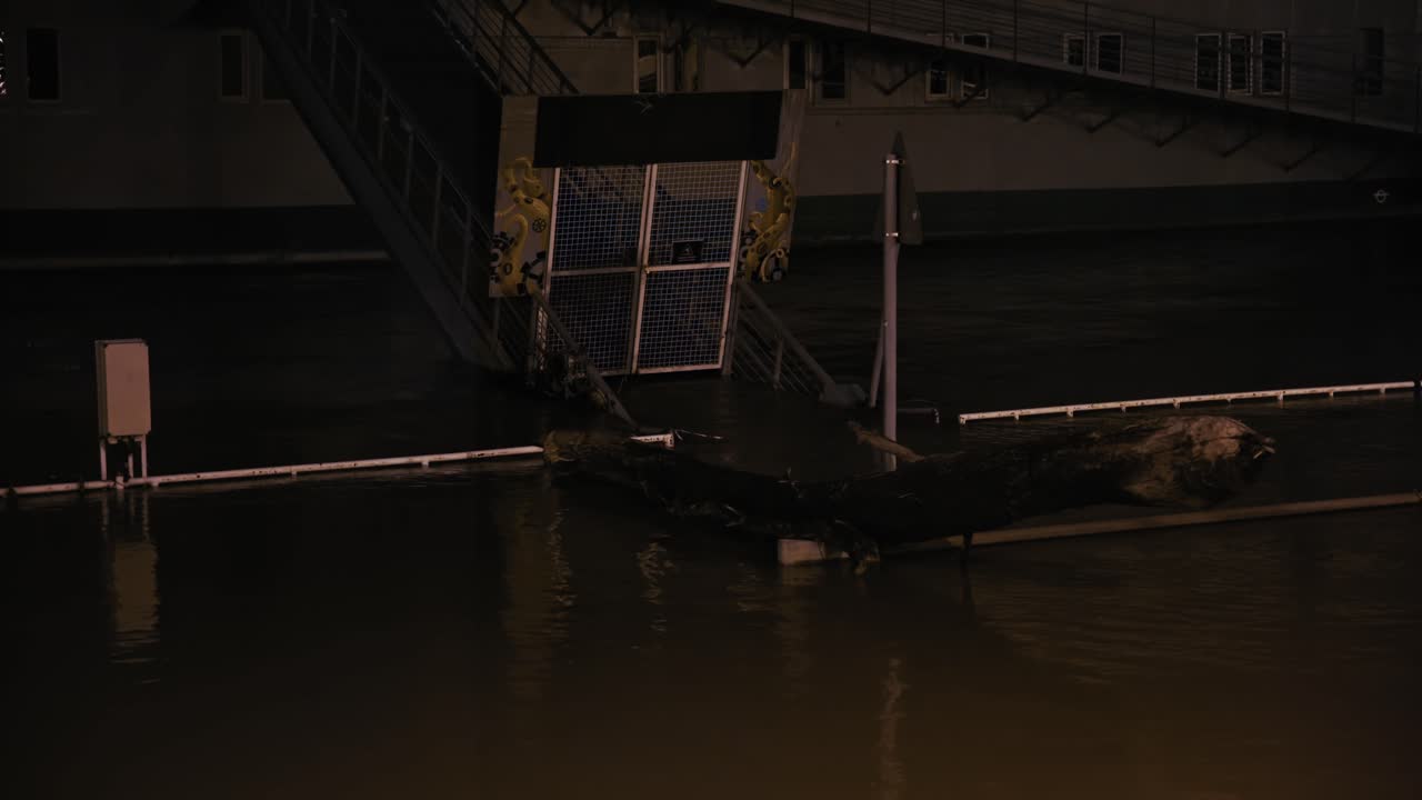 Large debris and partially submerged platform in floodwaters at night during the Budapest Flood 2024 along the Danube River
