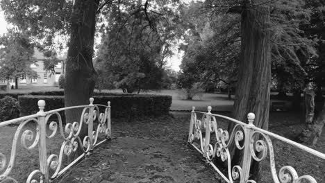 POV-Spaziergang-Auf-Einer-Weißen-Gartenbrücke-In-Schwarz-Und-Weiß