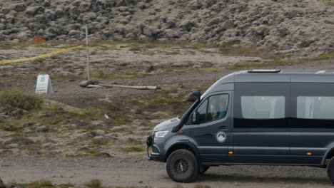 a tour bus arrives at a busy spot where people have gathered to see the erupting grindavik volcano in sundhnúkur crater, iceland.