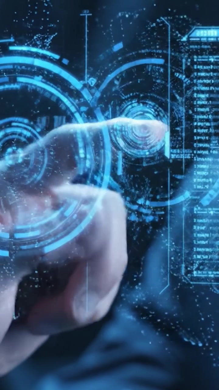 Primo piano della mano di una persona che opera un'interfaccia ad alta tecnologia con elementi digitali futuristici e display olografici in un ambiente moderno e scarsamente illuminato.