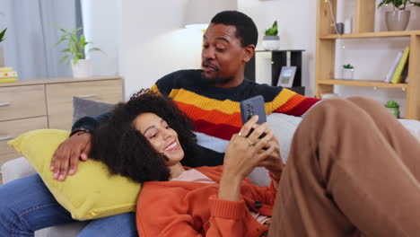 Black-couple,-phone-and-relax-on-sofa-in-home